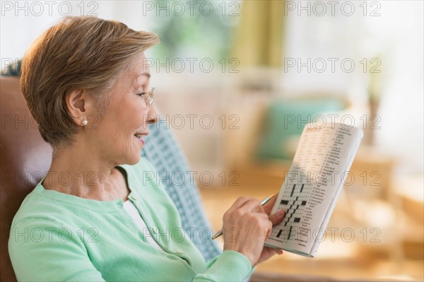 Senior woman doing crossword puzzle.