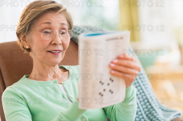 Senior woman doing crossword puzzle.