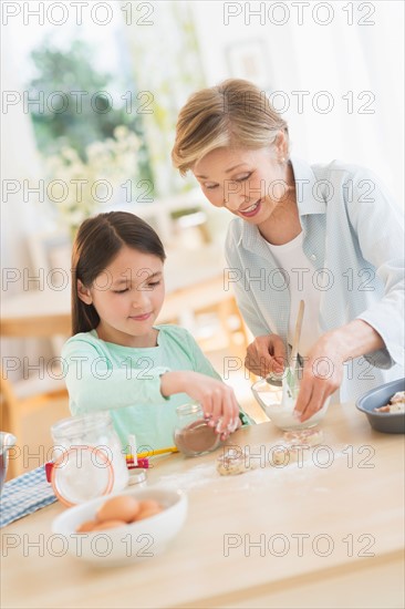 Granddaughter (8-9) cooking with grandmother.