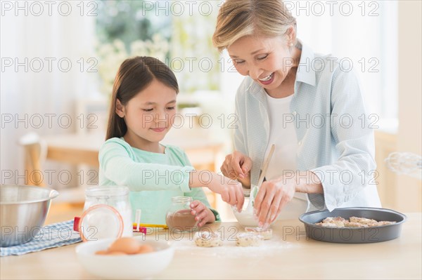 Granddaughter (8-9) cooking with grandmother.