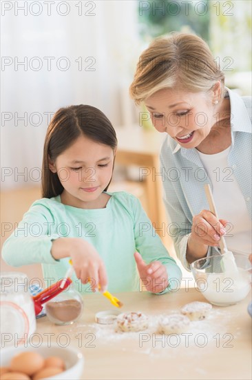 Granddaughter (8-9) cooking with grandmother.