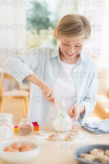 Senior woman cooking in kitchen.