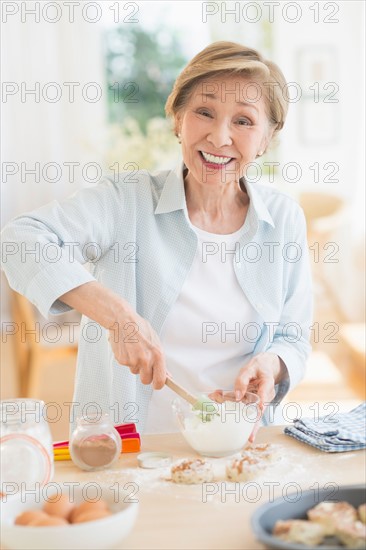 Senior woman cooking in kitchen.