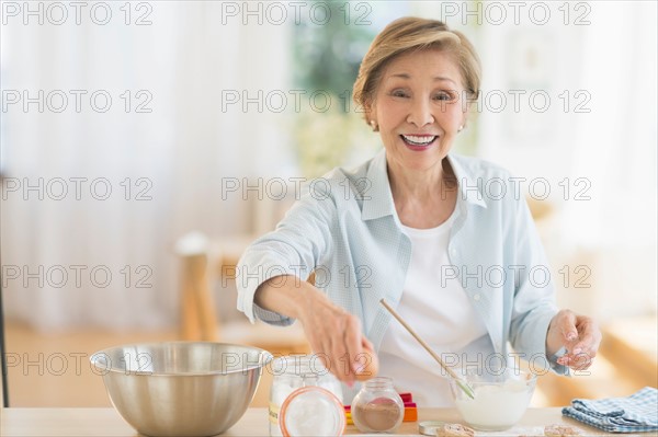 Senior woman cooking in kitchen.