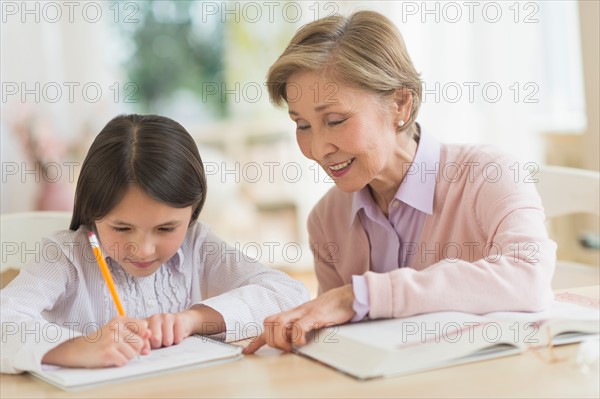 Grandmother and granddaughter (8-9) doing homework.