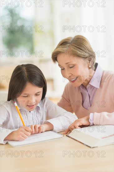 Grandmother and granddaughter (8-9) doing homework.