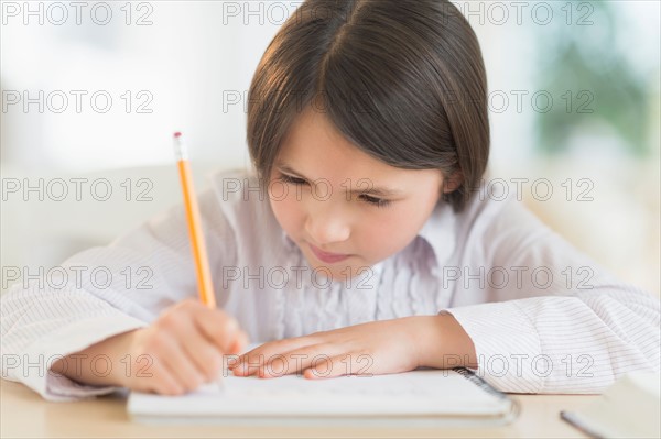 Girl (8-9) doing homework.