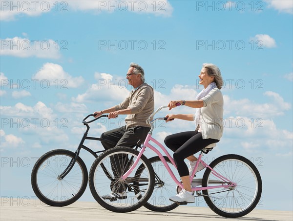 Senior couple riding bicycle.