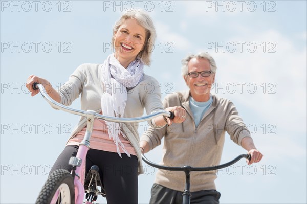 Senior couple riding bicycle.