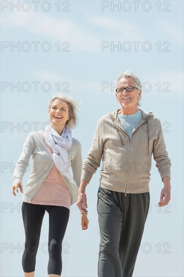 Senior couple walking and holding hands.