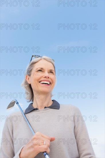 Senior woman holding golf club.