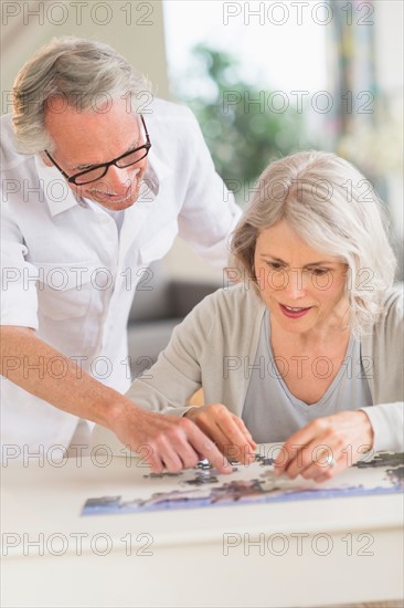 Senior woman completing jigsaw puzzle.