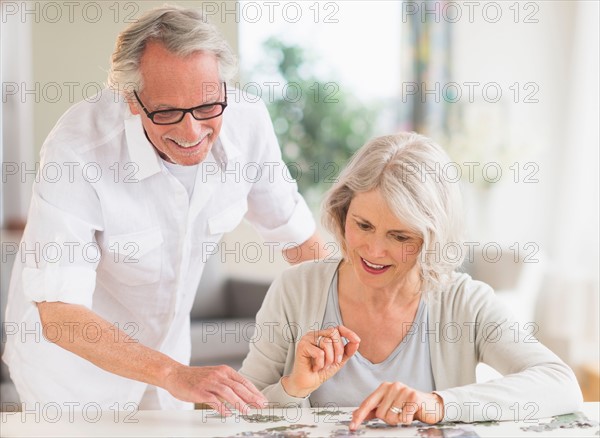 Senior woman completing jigsaw puzzle.