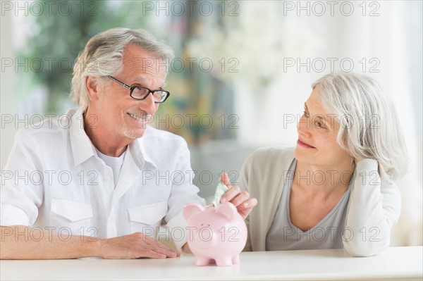 Senior couple with piggybank.