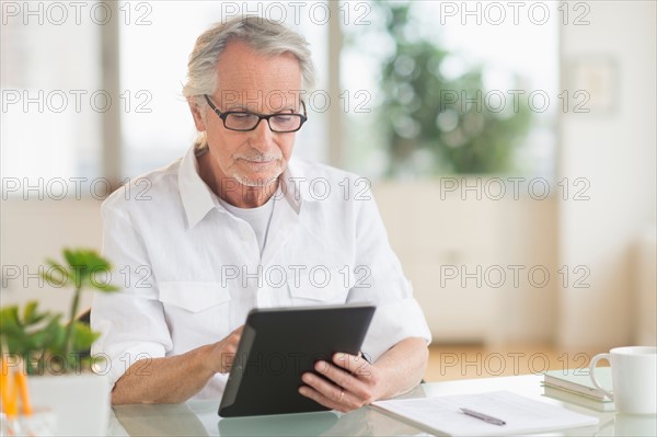 Senior man using digital tablet.