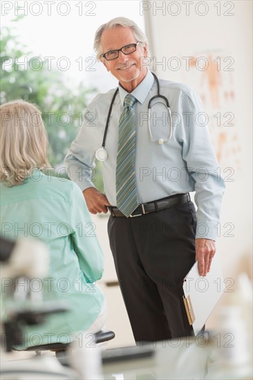 Male doctor talking to female patient in his office.