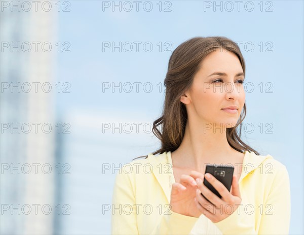 Young woman photographing herself with mobile phone.