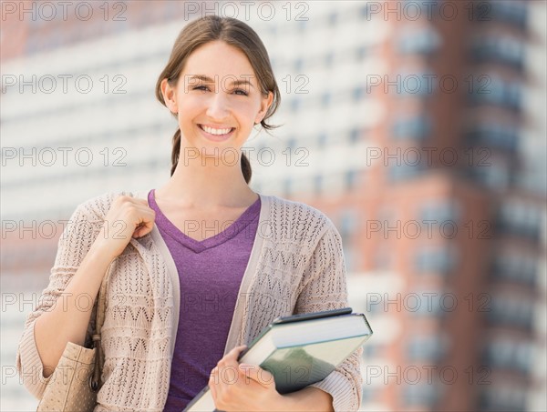 Portrait of smiling female student with book.