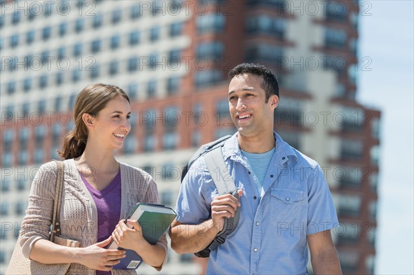 Male and female students walking in campus.