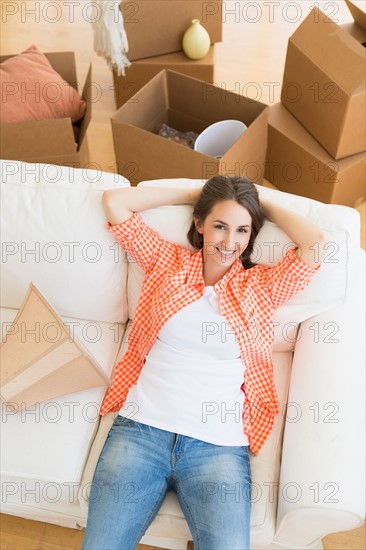 Young woman resting on sofa after moving into new home.