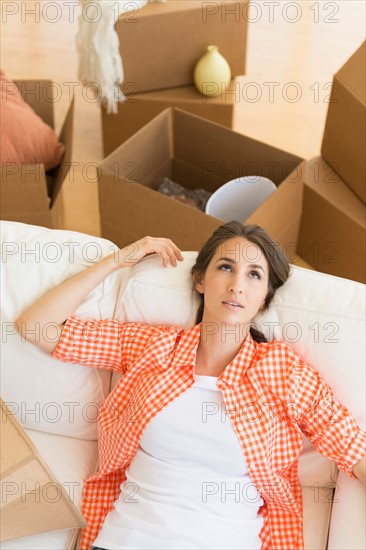 Young woman resting on sofa after moving into new home.