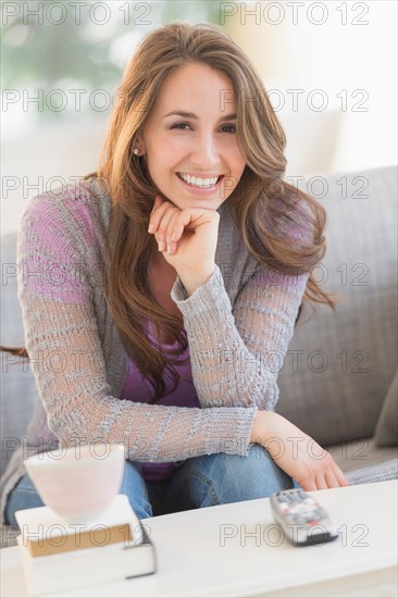 Young woman sitting on sofa.