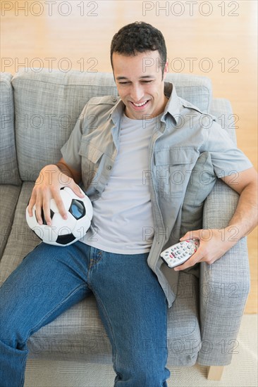 Young man watching soccer match on tv.