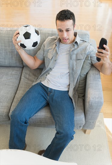 Young man watching soccer match on tv.