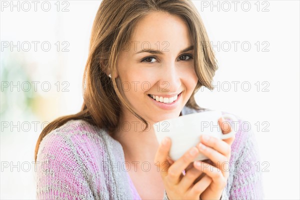 Portrait of young woman drinking tea.