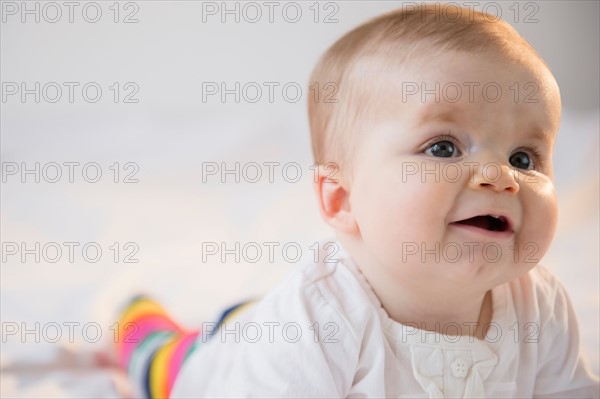 Portrait of baby girl (6-11 months) lying on bed