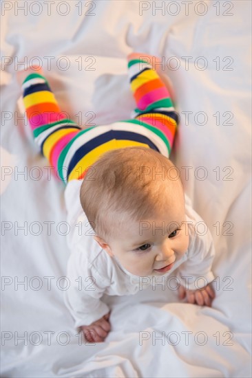 Portrait of baby girl (6-11 months) lying on bed