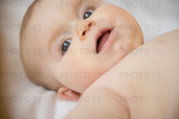 Portrait of baby girl (6-11 months) lying down