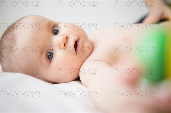 Portrait of baby girl (6-11 months) lying down