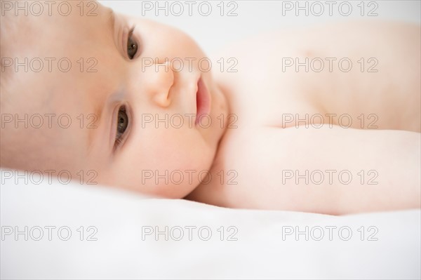 Portrait of baby girl (6-11 months) lying down