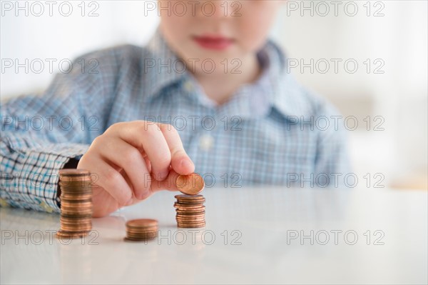 Boy (4-5) stacking coins