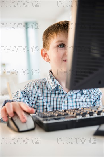 Portrait of boy (4-5) using desktop PC