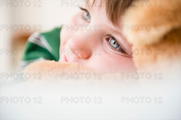 Portrait of boy (4-5) snuggling to teddy bear