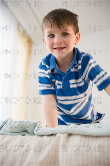 Portrait of boy (4-5) on bed