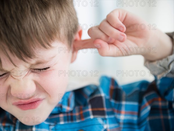 Portrait of boy (4-5) sticking fingers in his ears