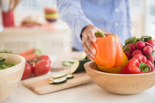 Mid section of woman holding pepper