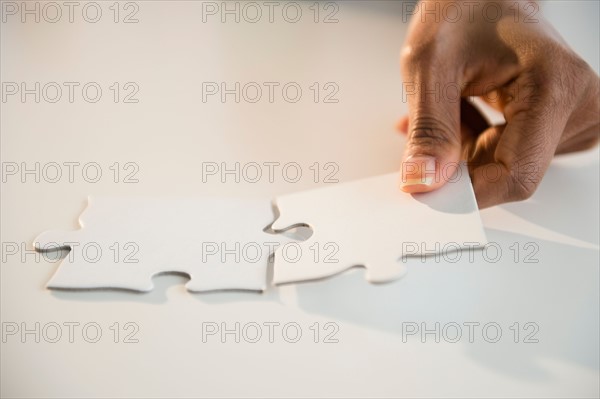 Woman's hands matching jigsaw puzzle