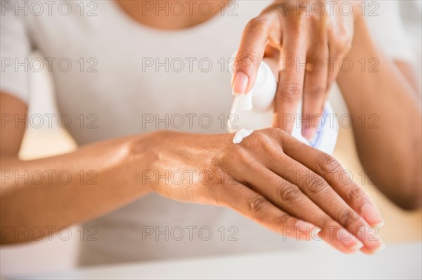 Close up of woman's hands applying moisturizer