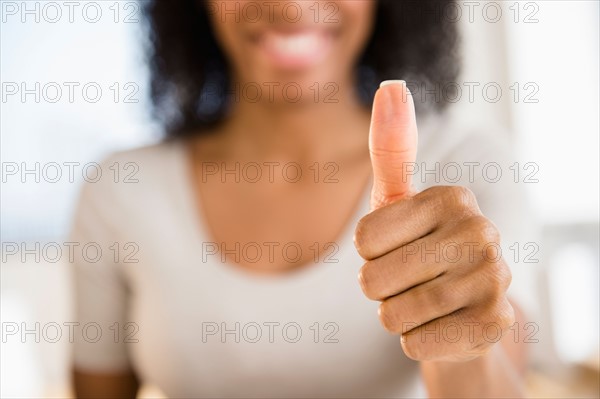 Woman making thumbs up gesture