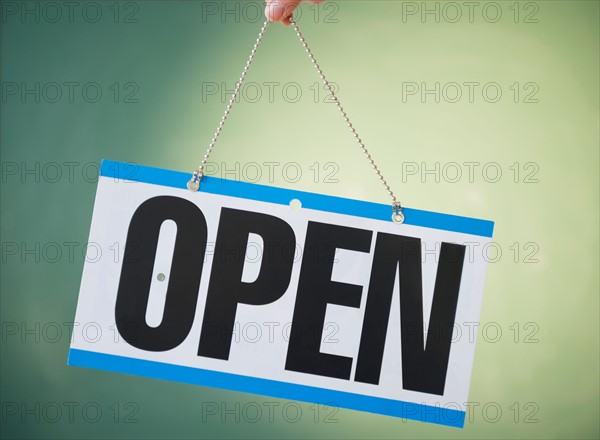 Studio Shot of human hand holding open sign