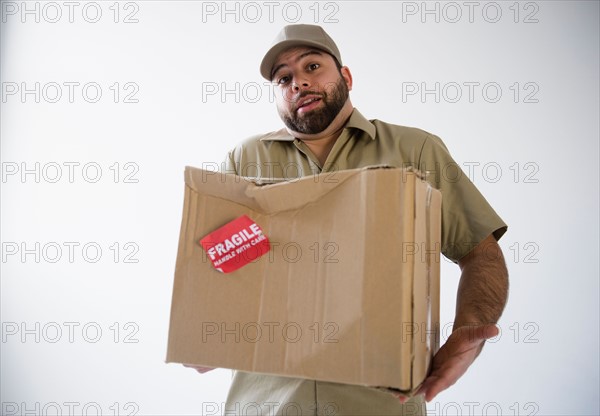 Delivery man holding damaged cardboard box