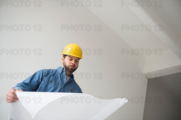 Portrait of construction worker looking at blueprints