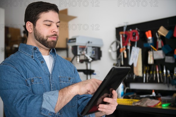 Portrait of man using digital tablet in workshop