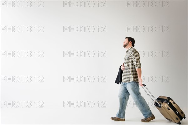 Side view of man walking with suitcase