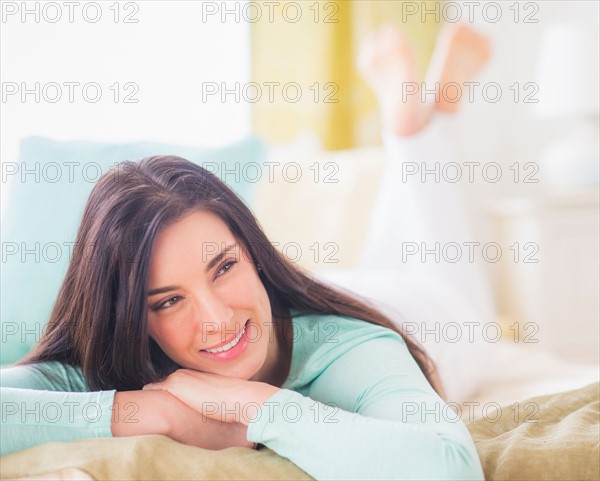 Portrait of woman lying down on bed with hand on chin, Looking away, Close-up
