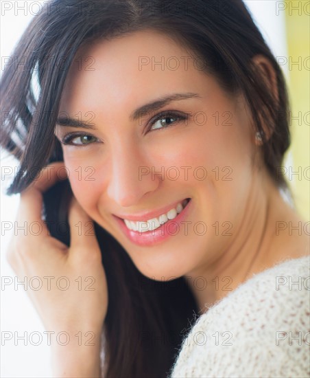 Portrait of woman with hand in hair, Looking at camera